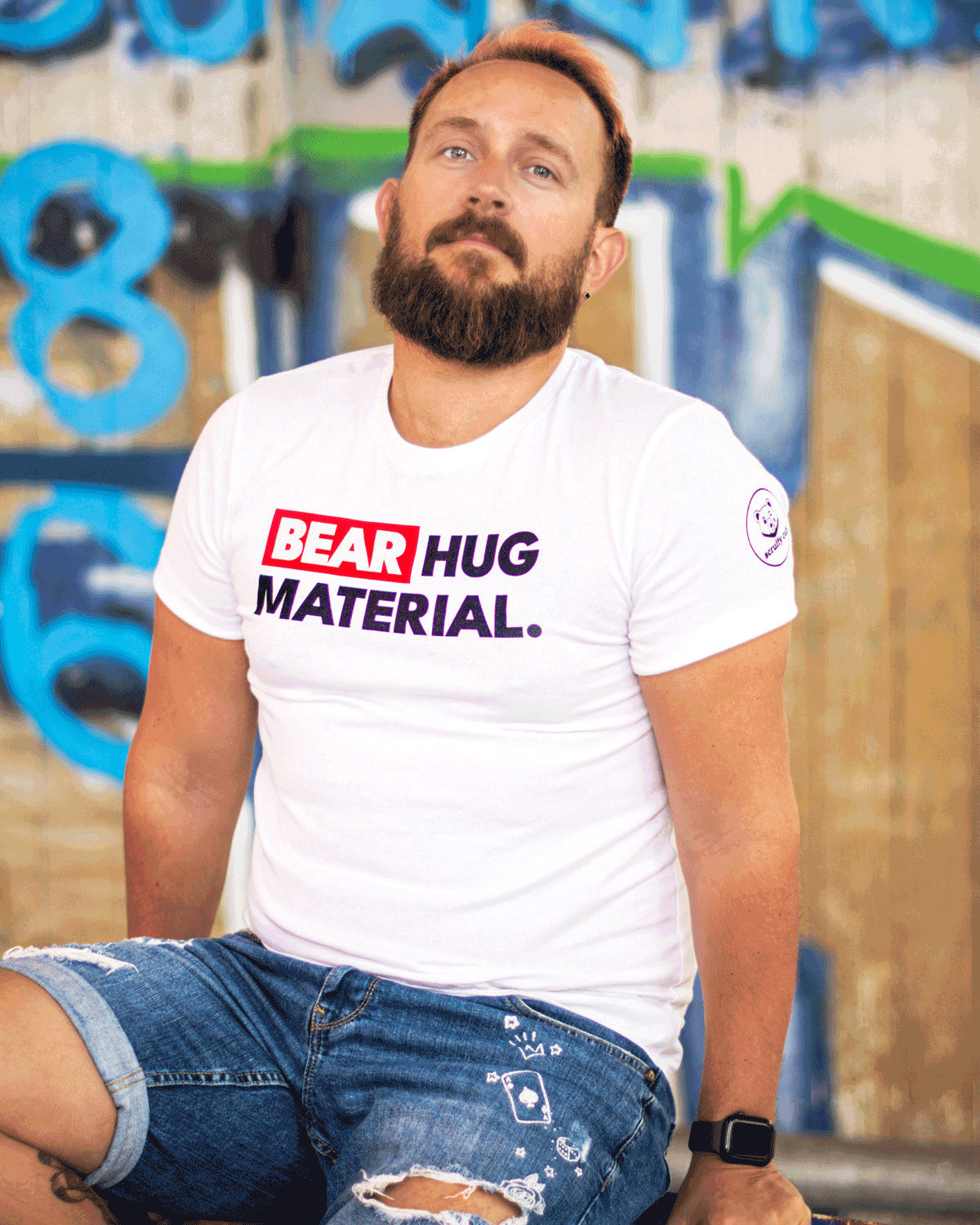 White Scruffy Cub Bear Hug Material men’s graphic T-shirt, bear-inspired clothing photographed in an urban setting